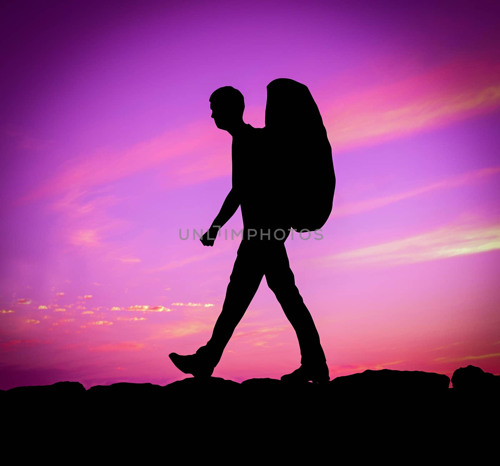 Silhouette Of A Hiker With Backpack Against A Purple Sunset