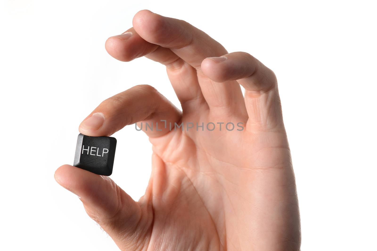 close up of a hand holding a help key from a computer keyboard on a white background