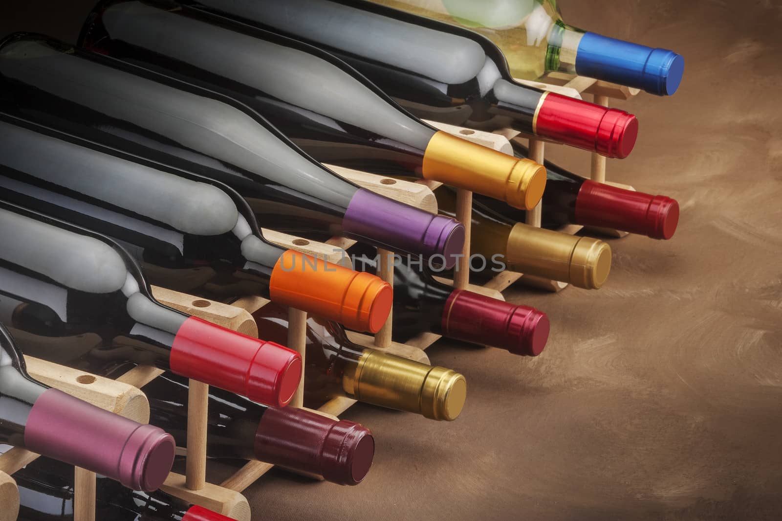 Wine bottles stacked on a wooden rack on a canvas background