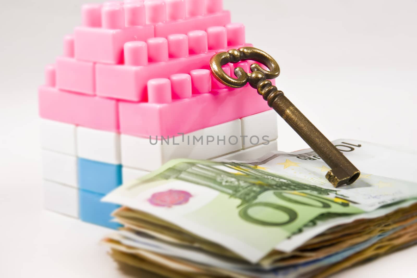  Miniature House with Key on a banknotes pile  isolated on white background