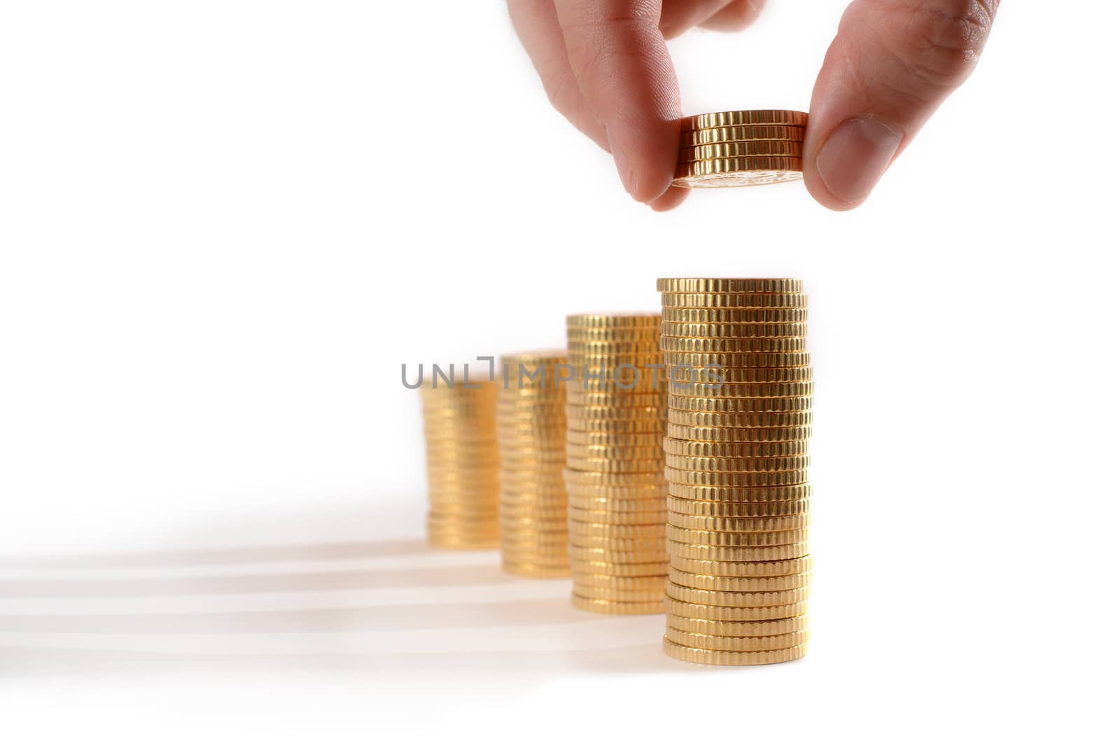 Male hand picking Euro Coins piled in stacks isolated on white background