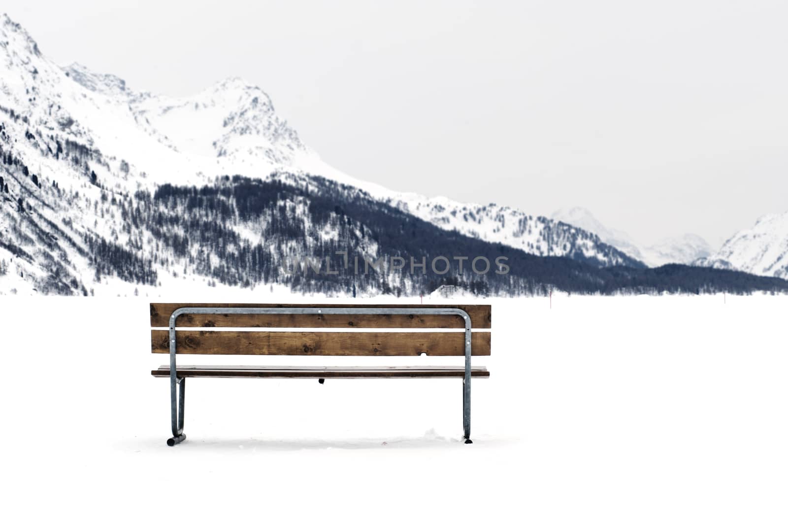 Wooden bench on a snowy winter landscape by ocusfocus