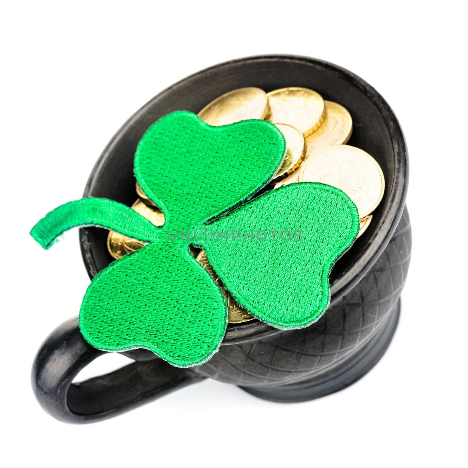 Black ceramic pot with golden coins and shamrock isolated on white. St. Patrick Day concept