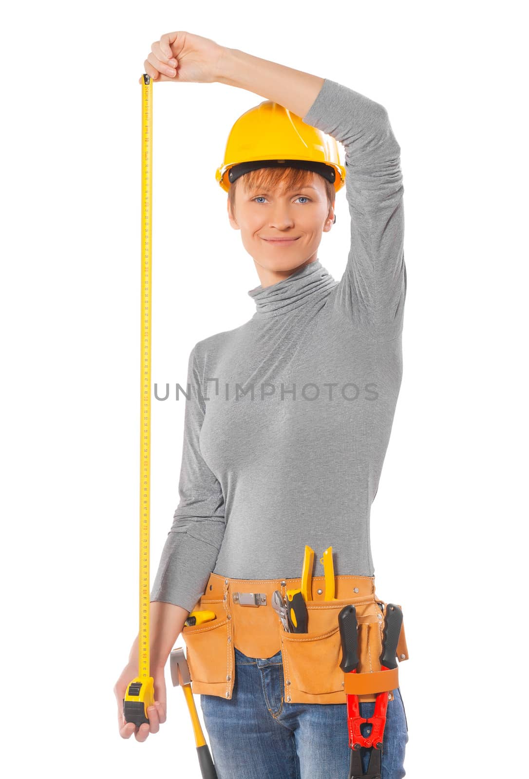 a young female holding a tape measure wearing work clothes isolated on white