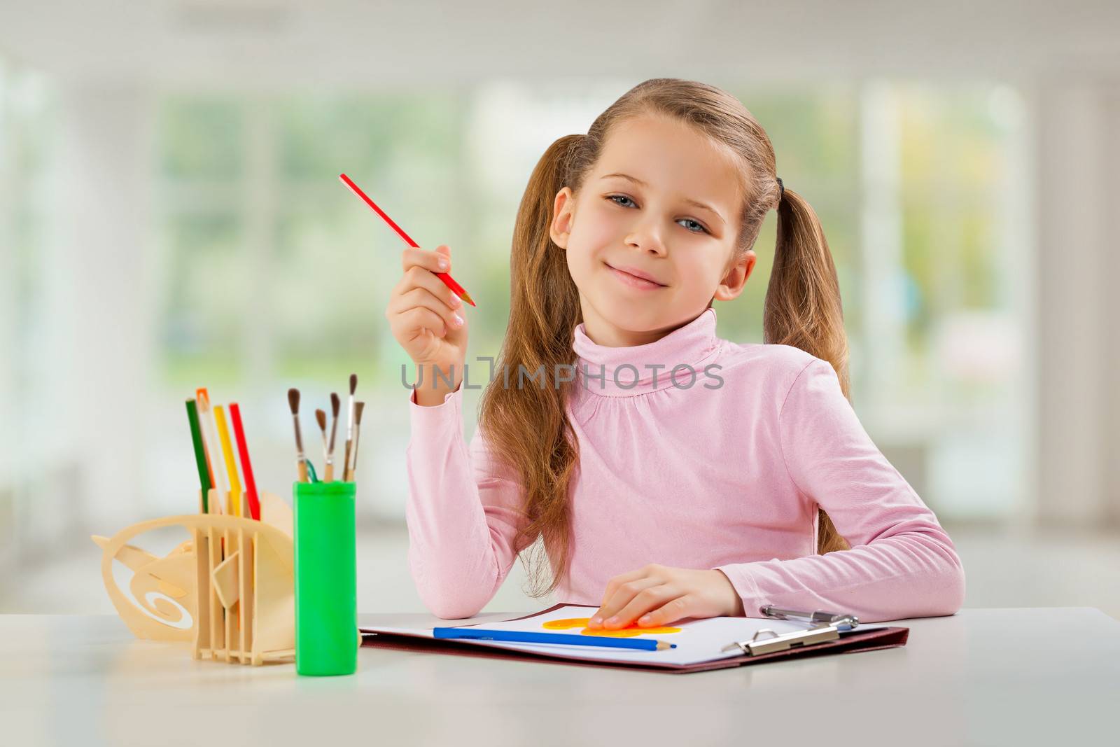 a young girl with pencil sitting at table