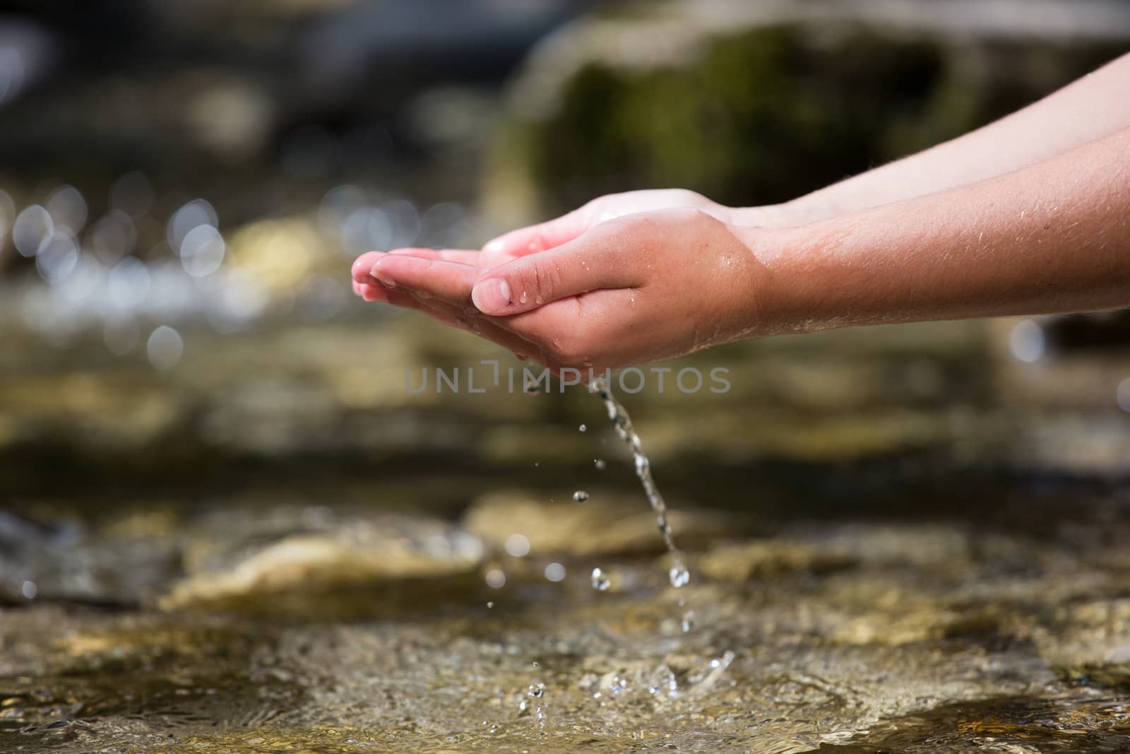 The hands taking out the water from the river