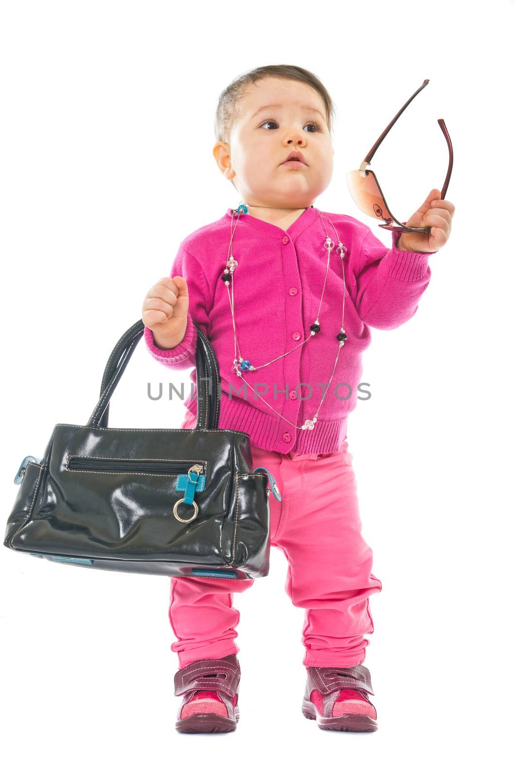 Baby in pink with sunglasses and hand bag isolated on white