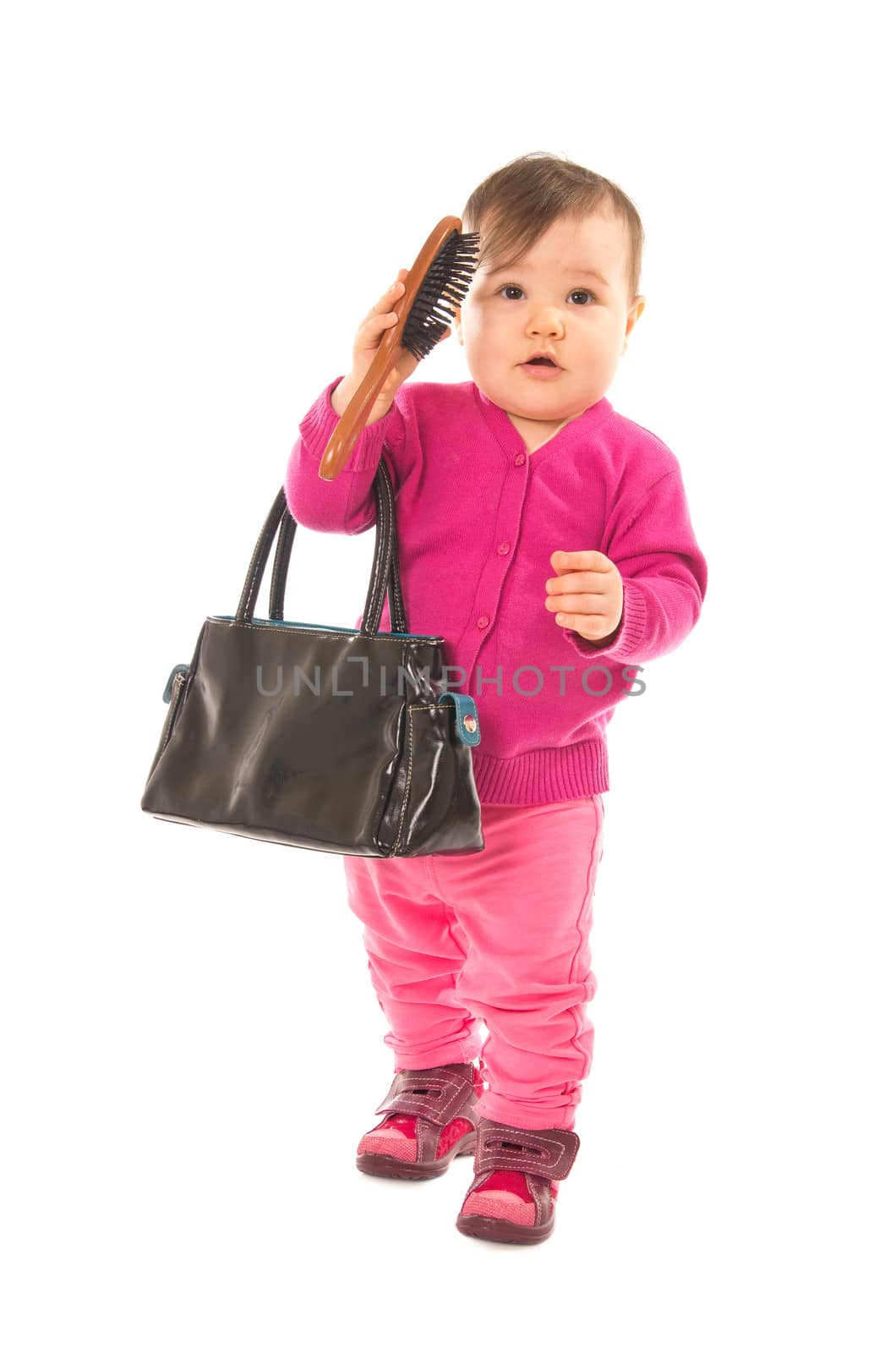 Baby girl with comb and hand bag over white