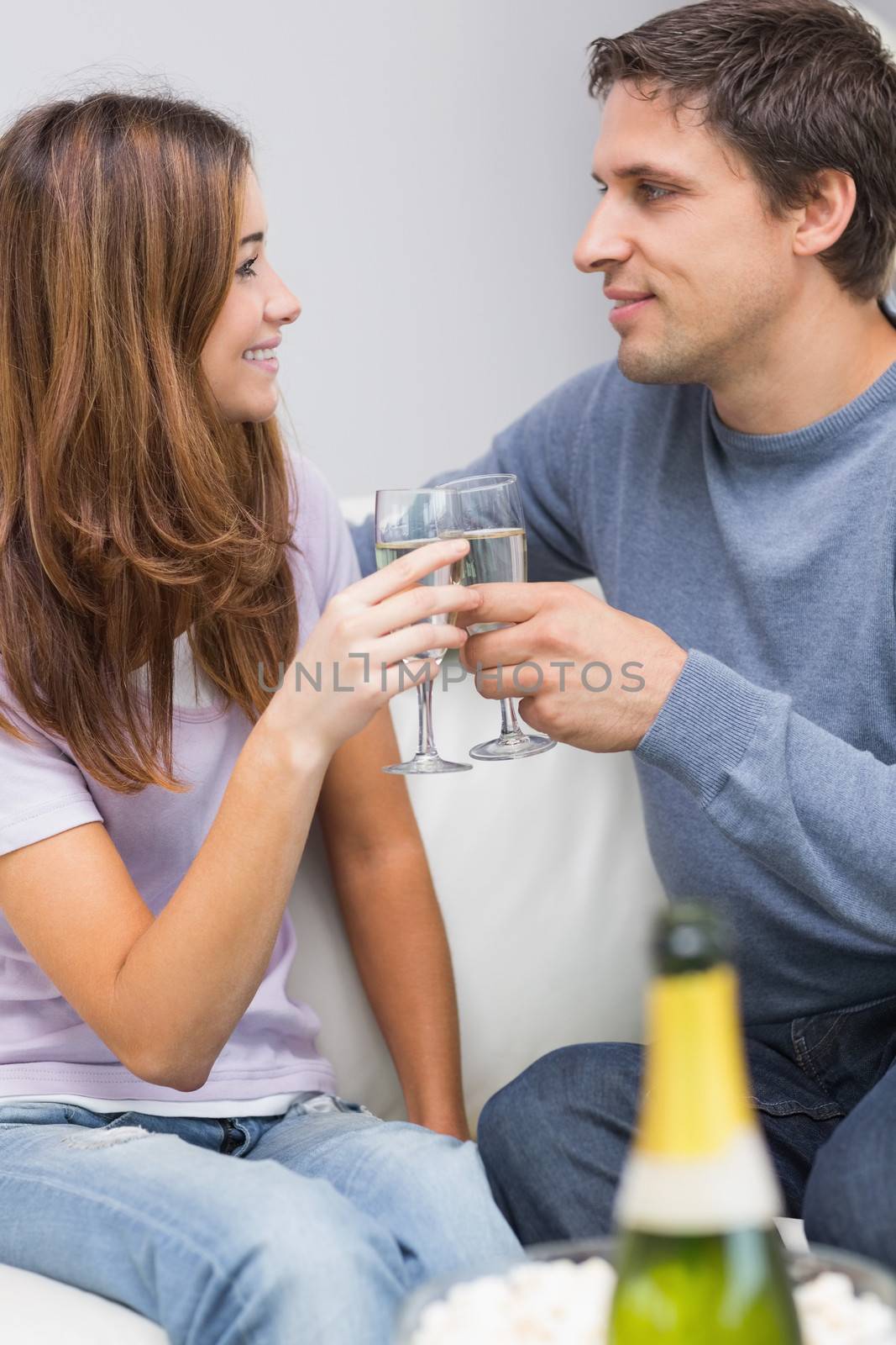 Romantic couple toasting flutes in the living room by Wavebreakmedia