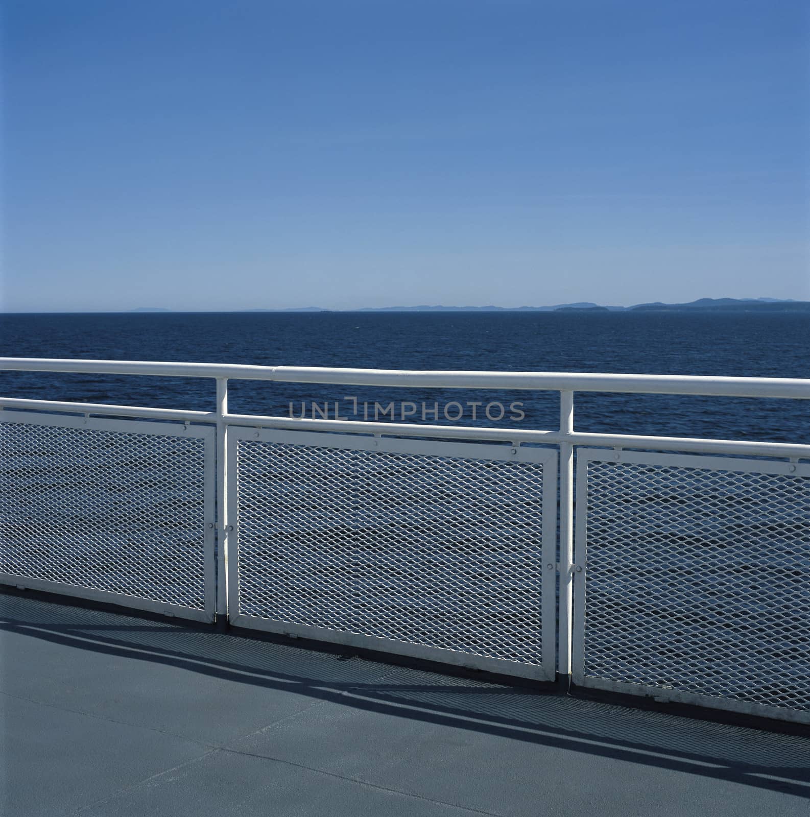 White metal railing against the blue ocean