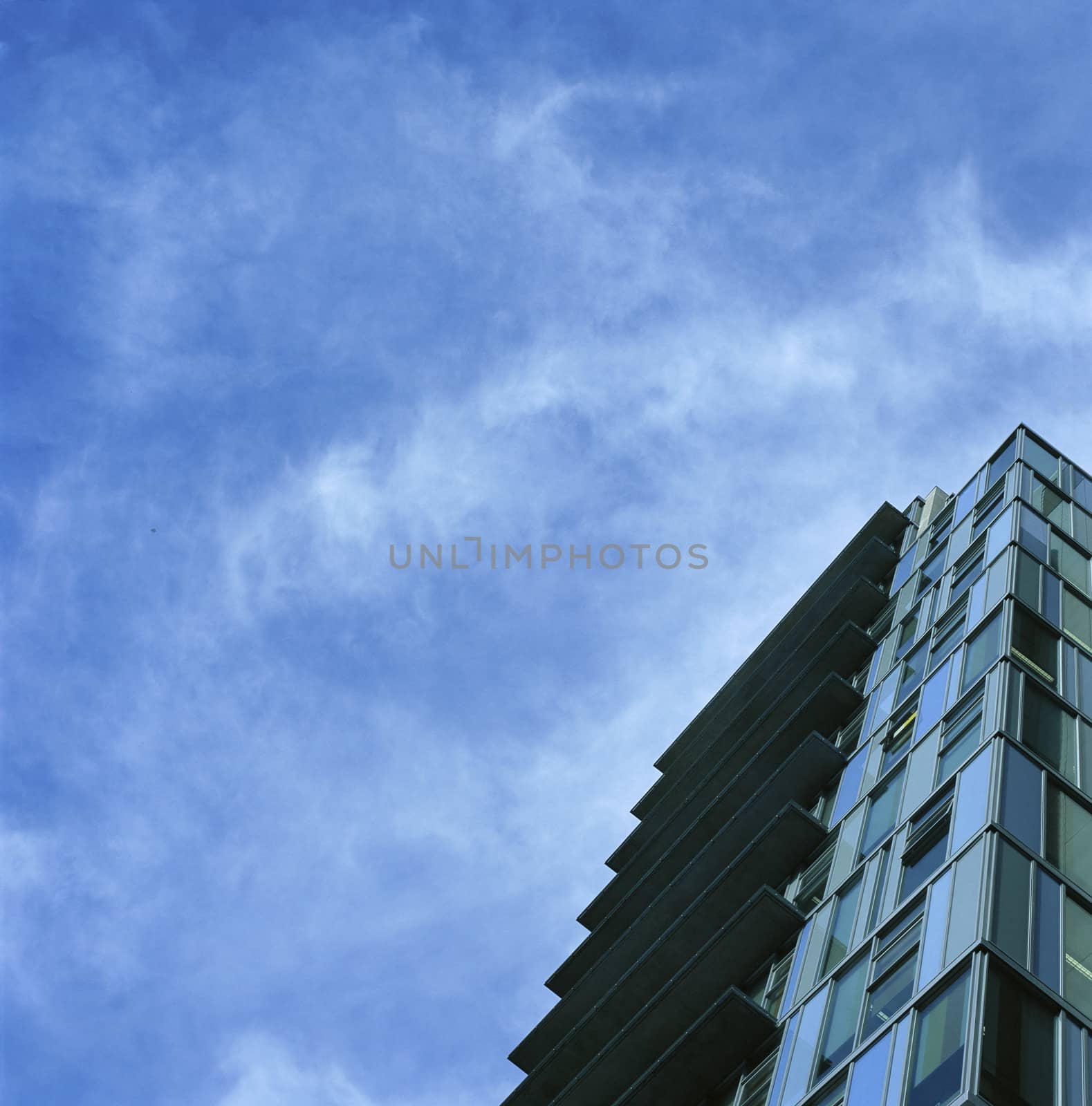 Tall, modern glass building against bright sky