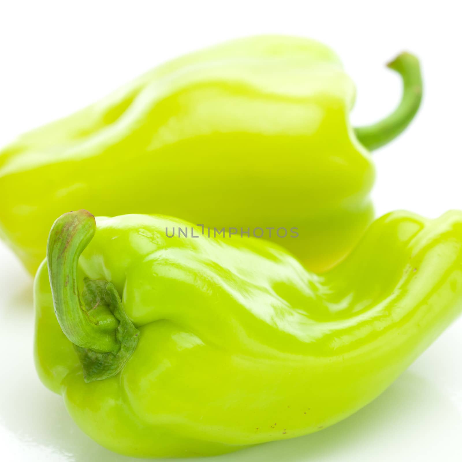 two green peppers isolated on white by jannyjus