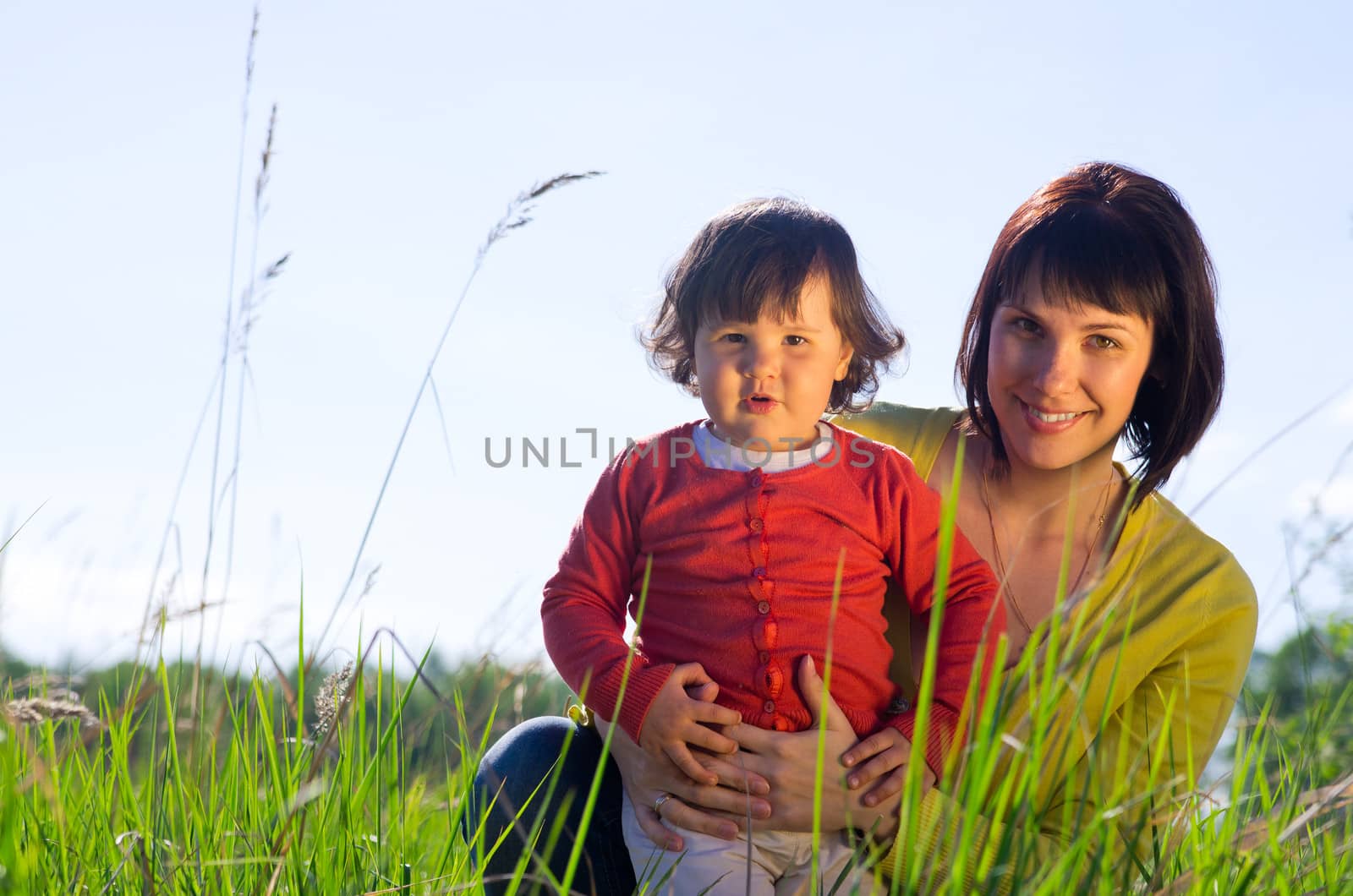 Young woman with small daughter outdoor on sunny day