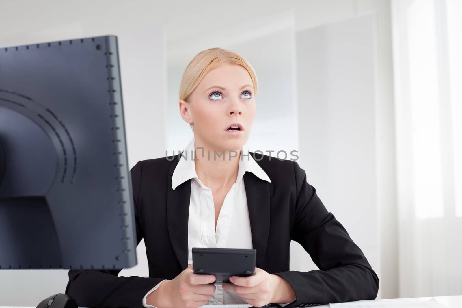 Cheerful young businesswoman with headache working in the office