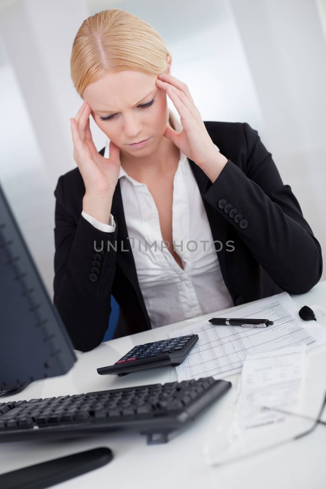 Cheerful young businesswoman with headache working in the office