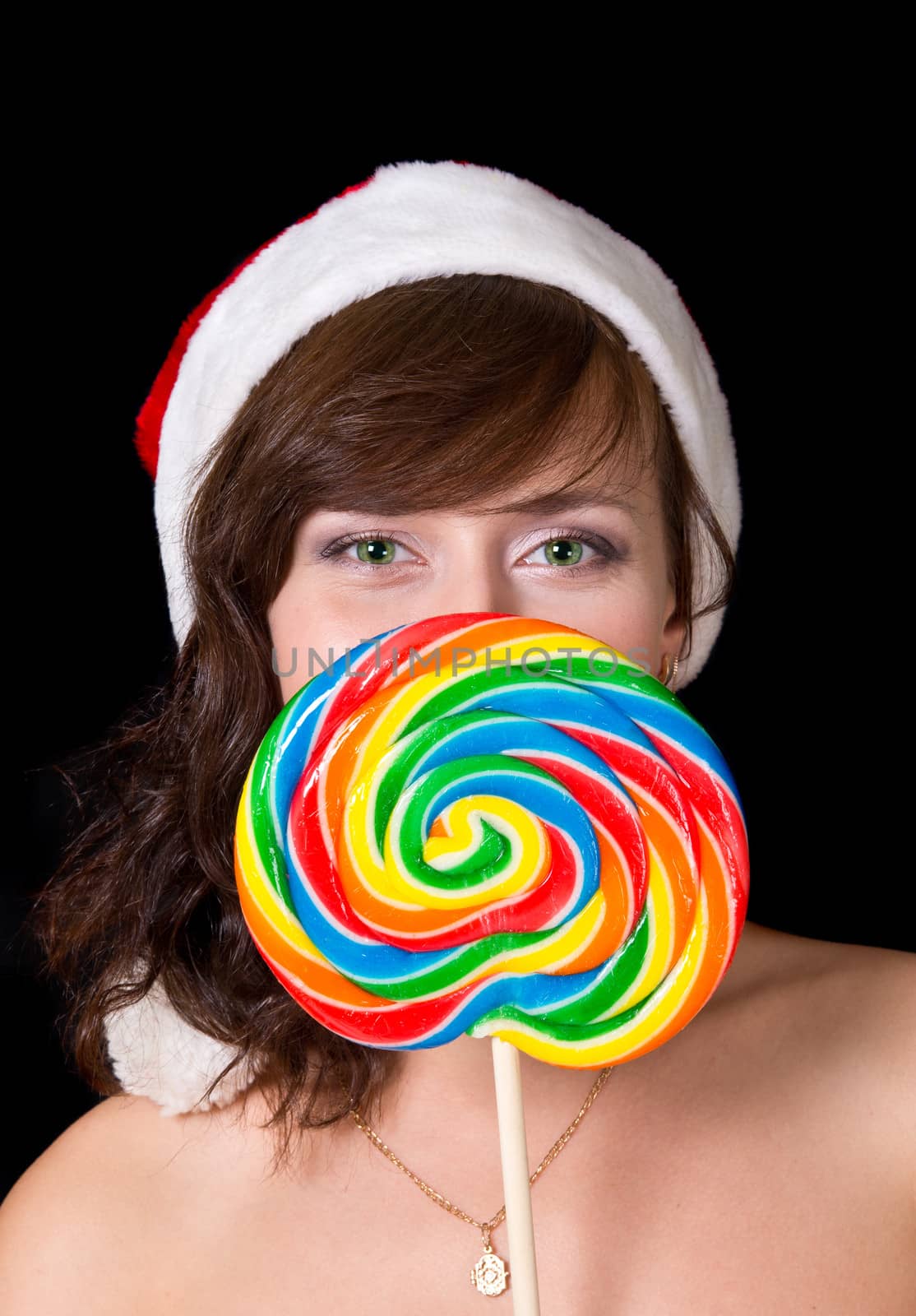 Portrait of young woman with green eyes with lollipop isolated on blackl
