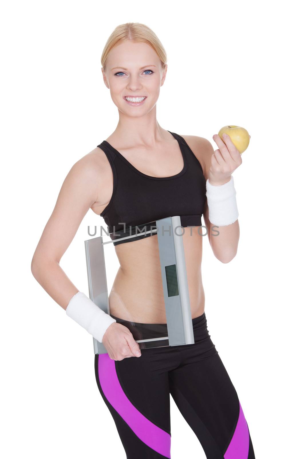 Beautiful young fitness woman with weights and apple. Isolated on white