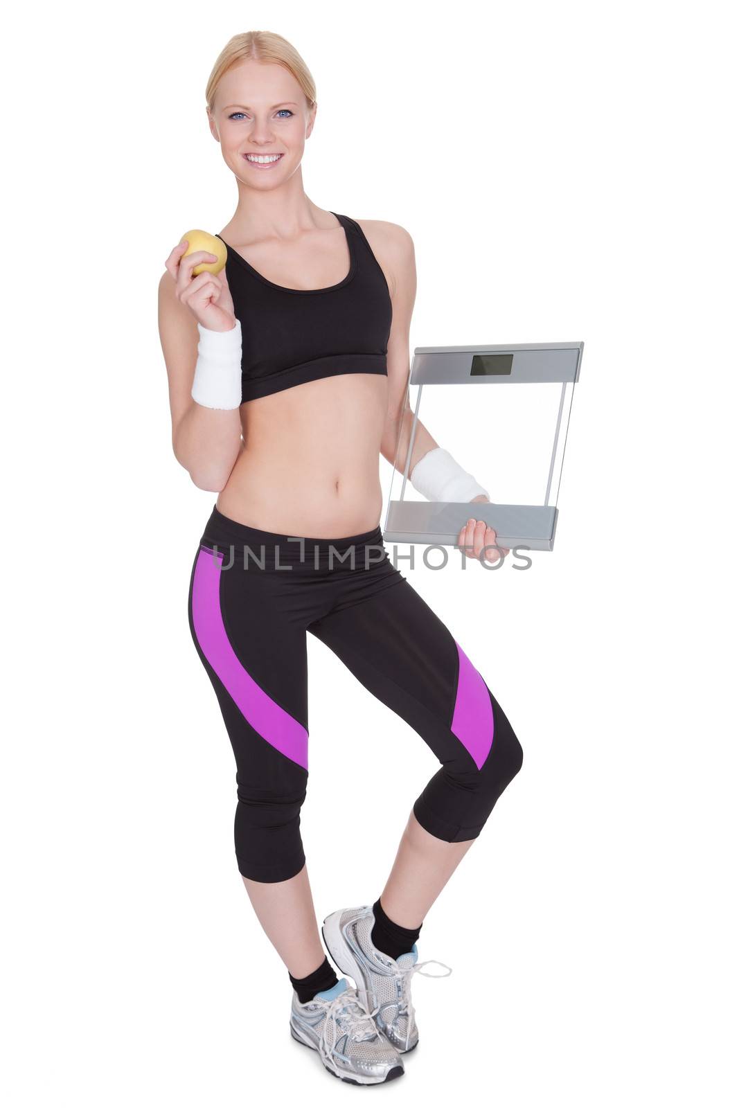 Beautiful young fitness woman with weights and apple. Isolated on white