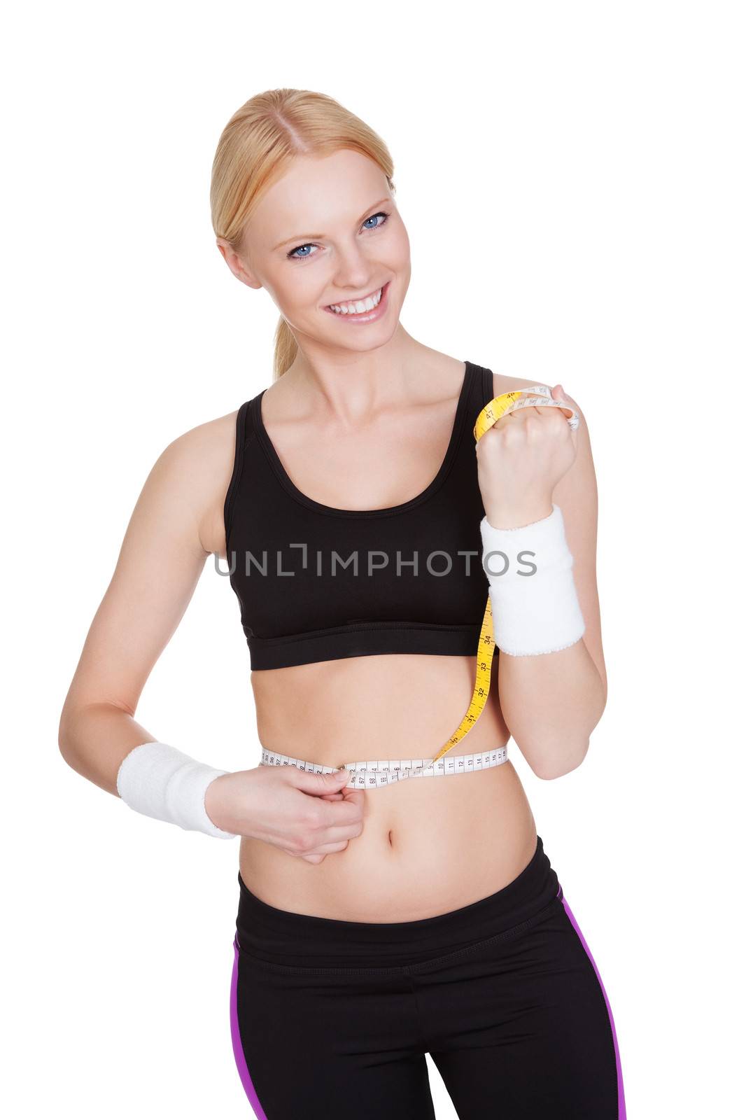 Beautiful fitness woman measuring waist. Isolated on white