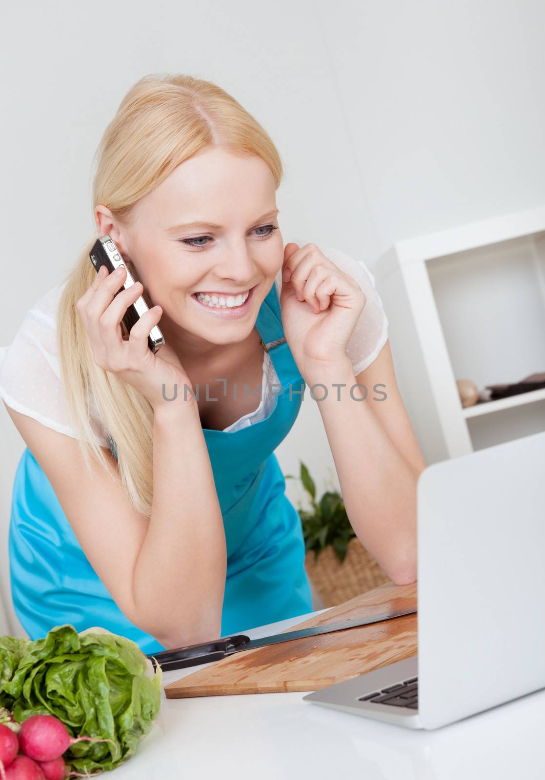 Cheerful young woman cooking in the kitchen