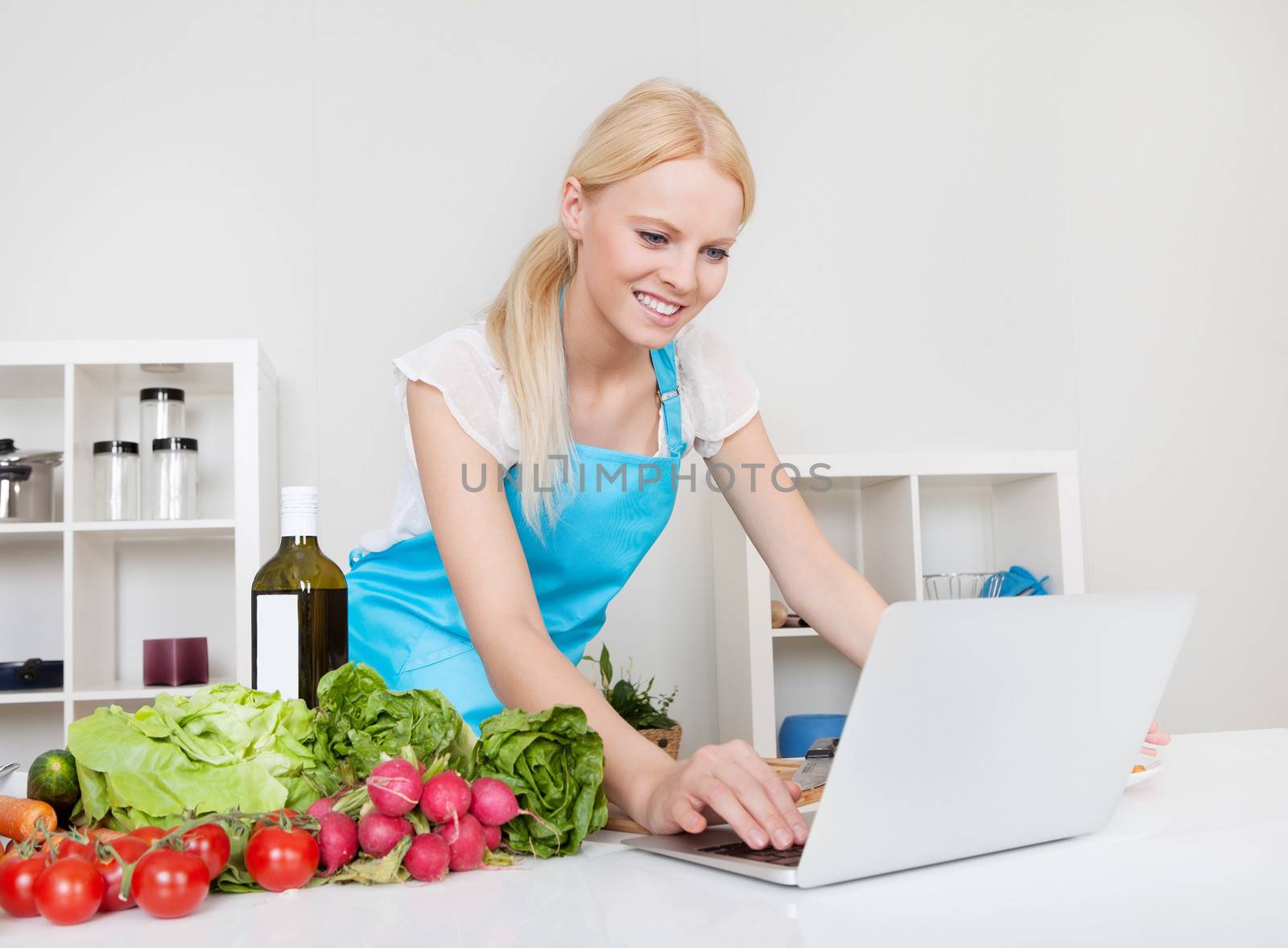 Cheerful young woman cooking in the kitchen