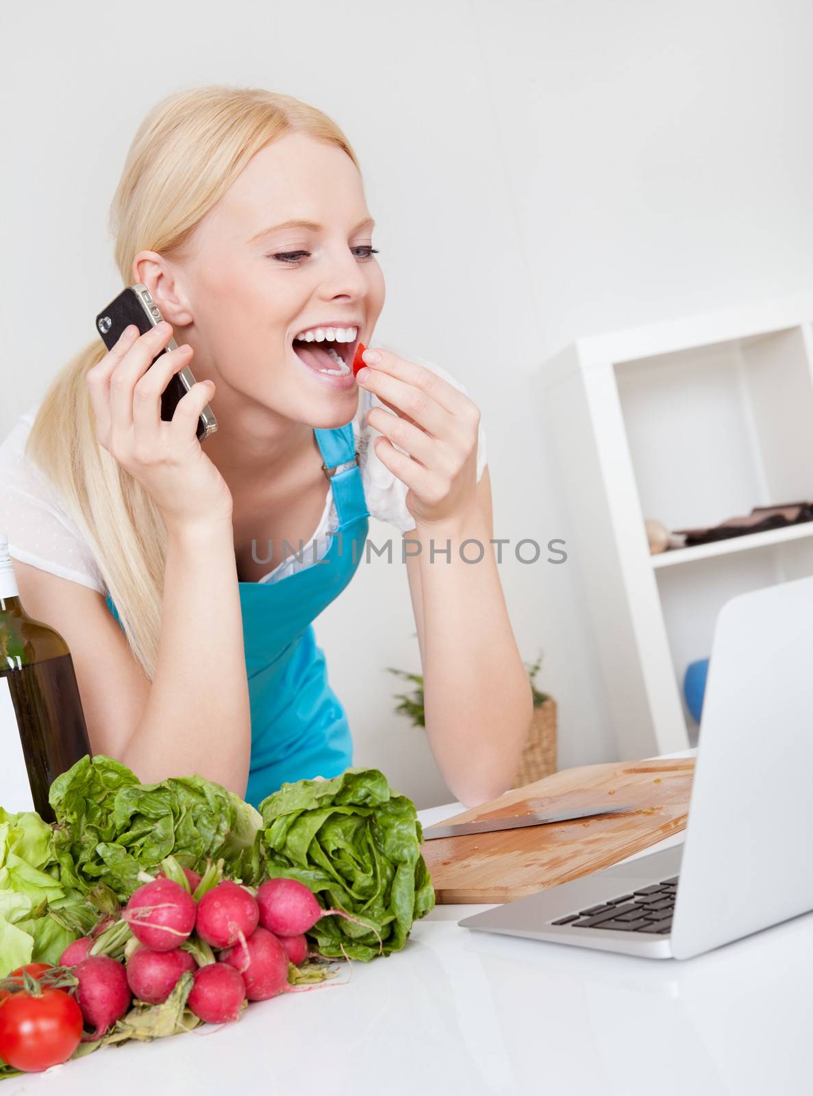 Cheerful young woman cooking in the kitchen