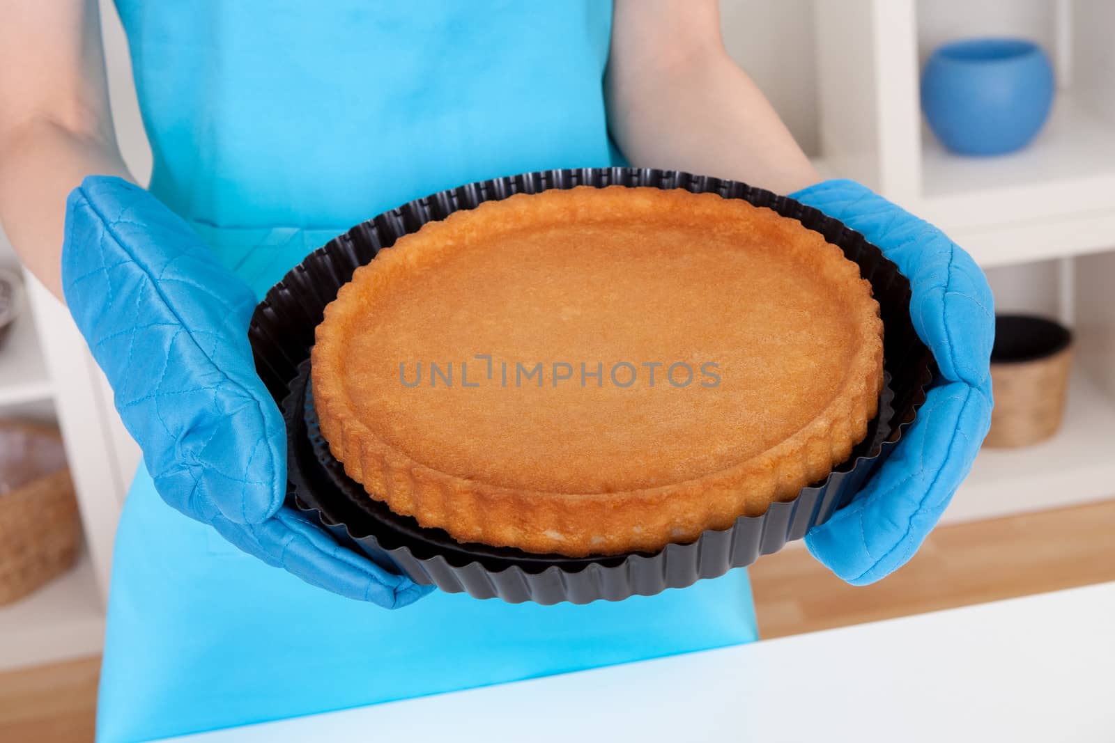 Close-up on young woman holding cake in the kitchen