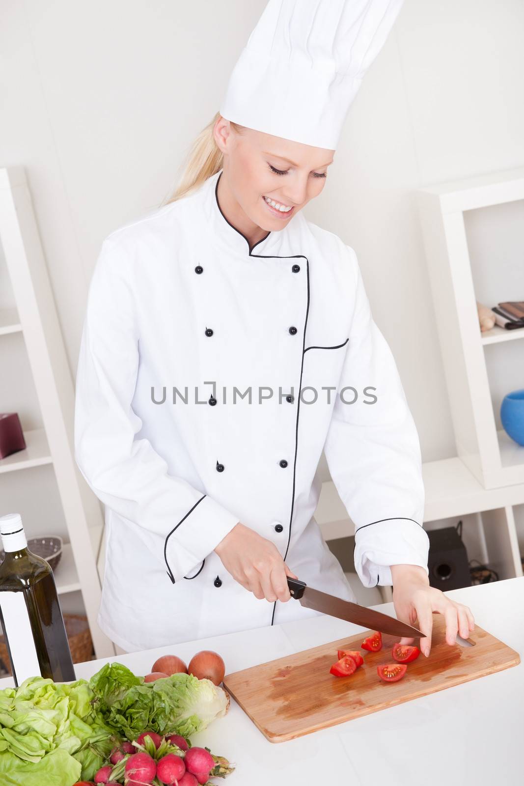 Cheerful woman chef cooking in the kitchen