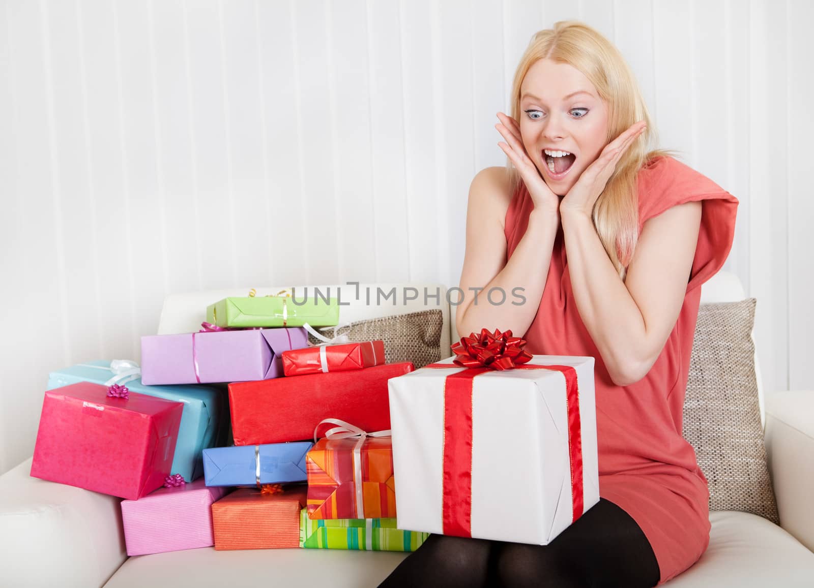 Beautiful young woman with her presents on the sofa