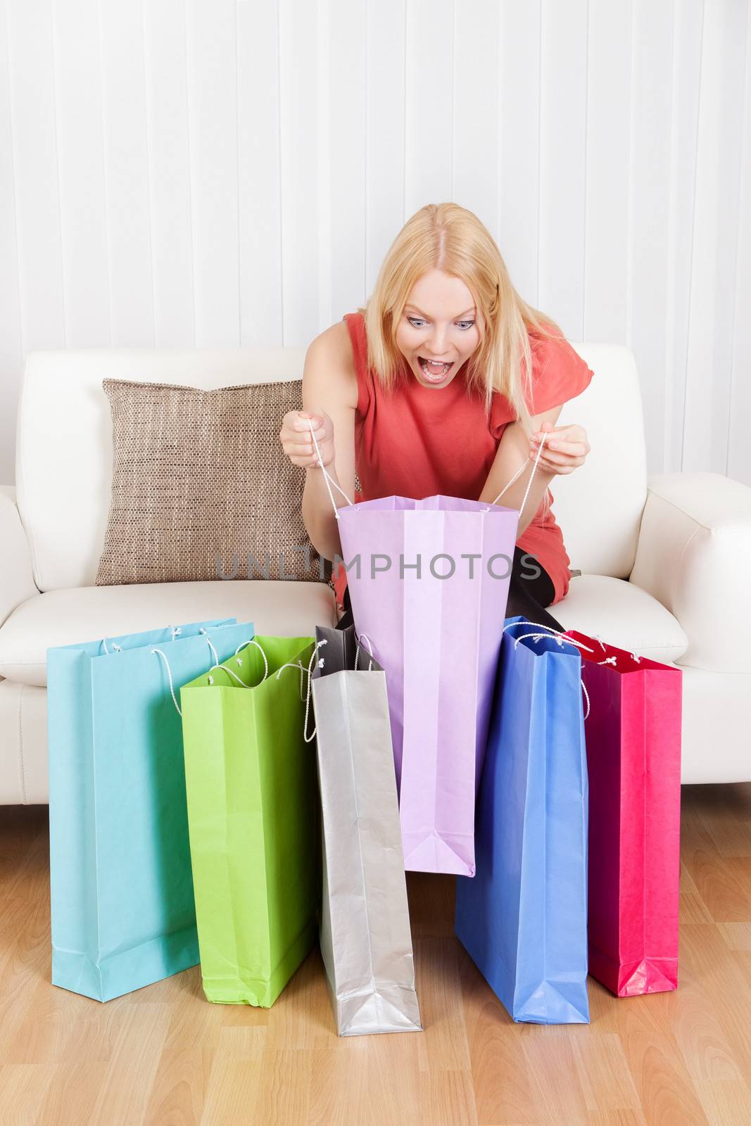 Beautiful young woman checking the shopping bags by AndreyPopov