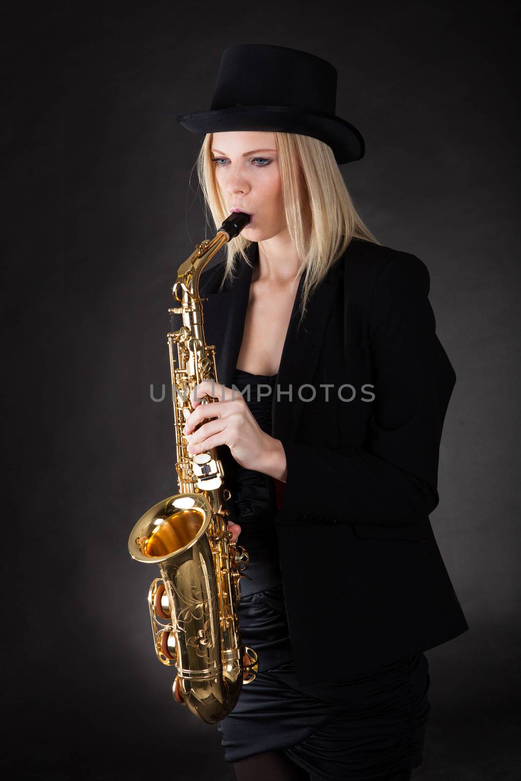 Beautiful young woman playing saxophone by AndreyPopov