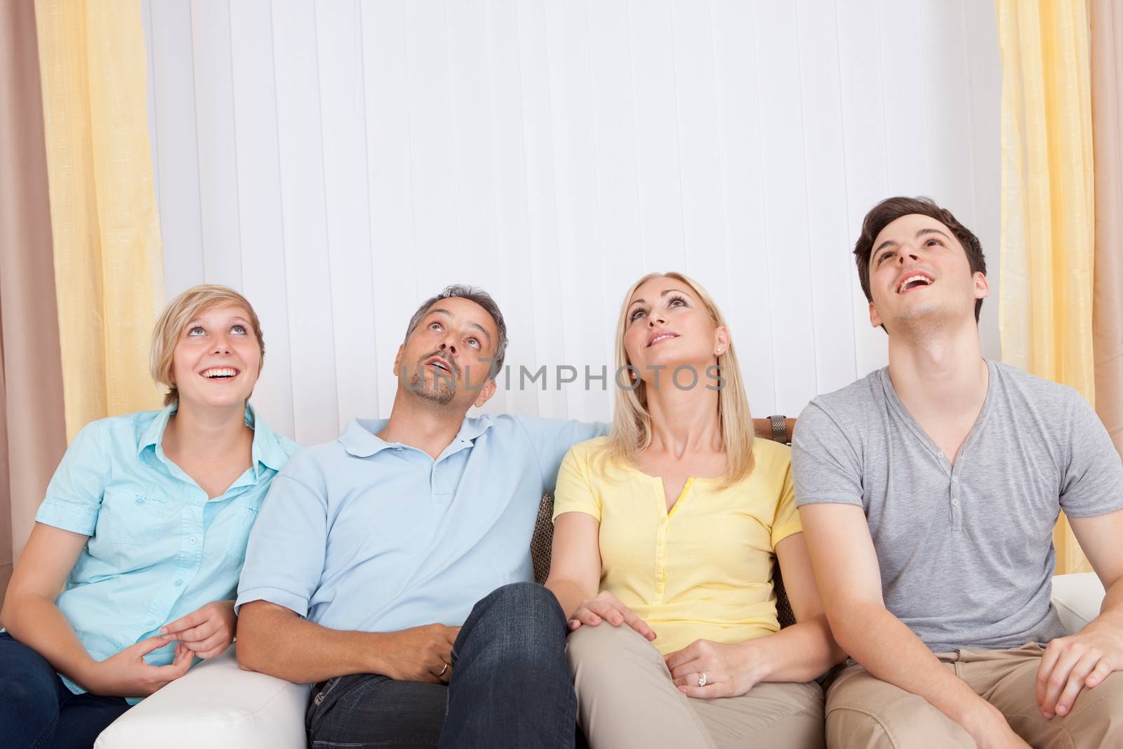 Smiling attractive young family with a teenage son and daughter posing together in group portrait