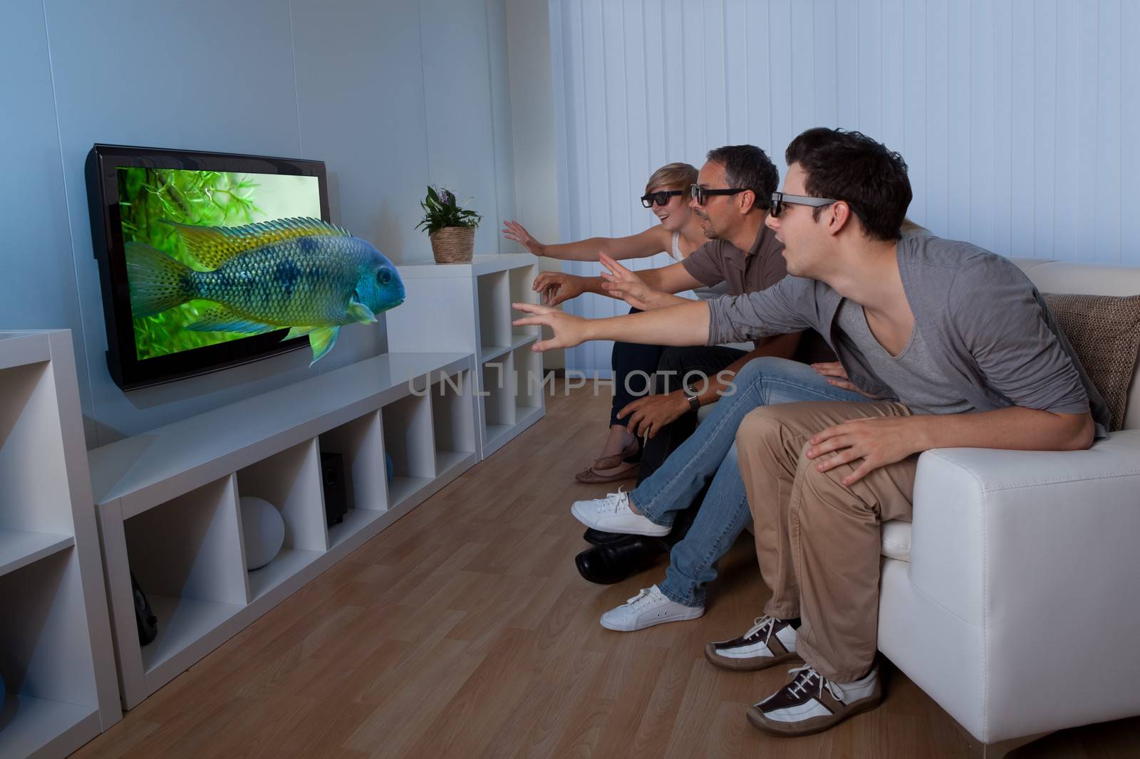 Family watching 3D television by AndreyPopov