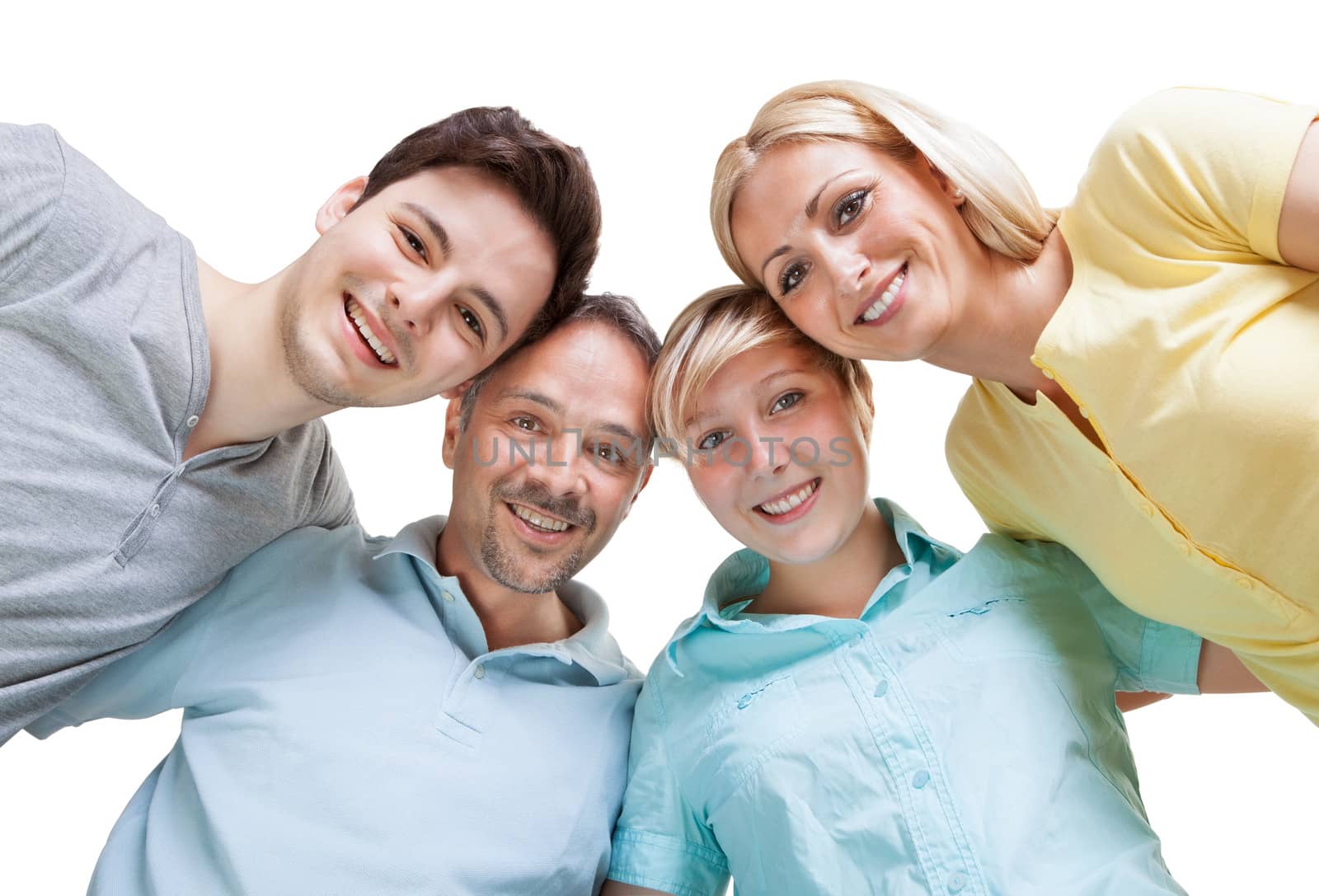 Happy family standing in a circle with their heads close together looking down at the camera with cheerful smiles