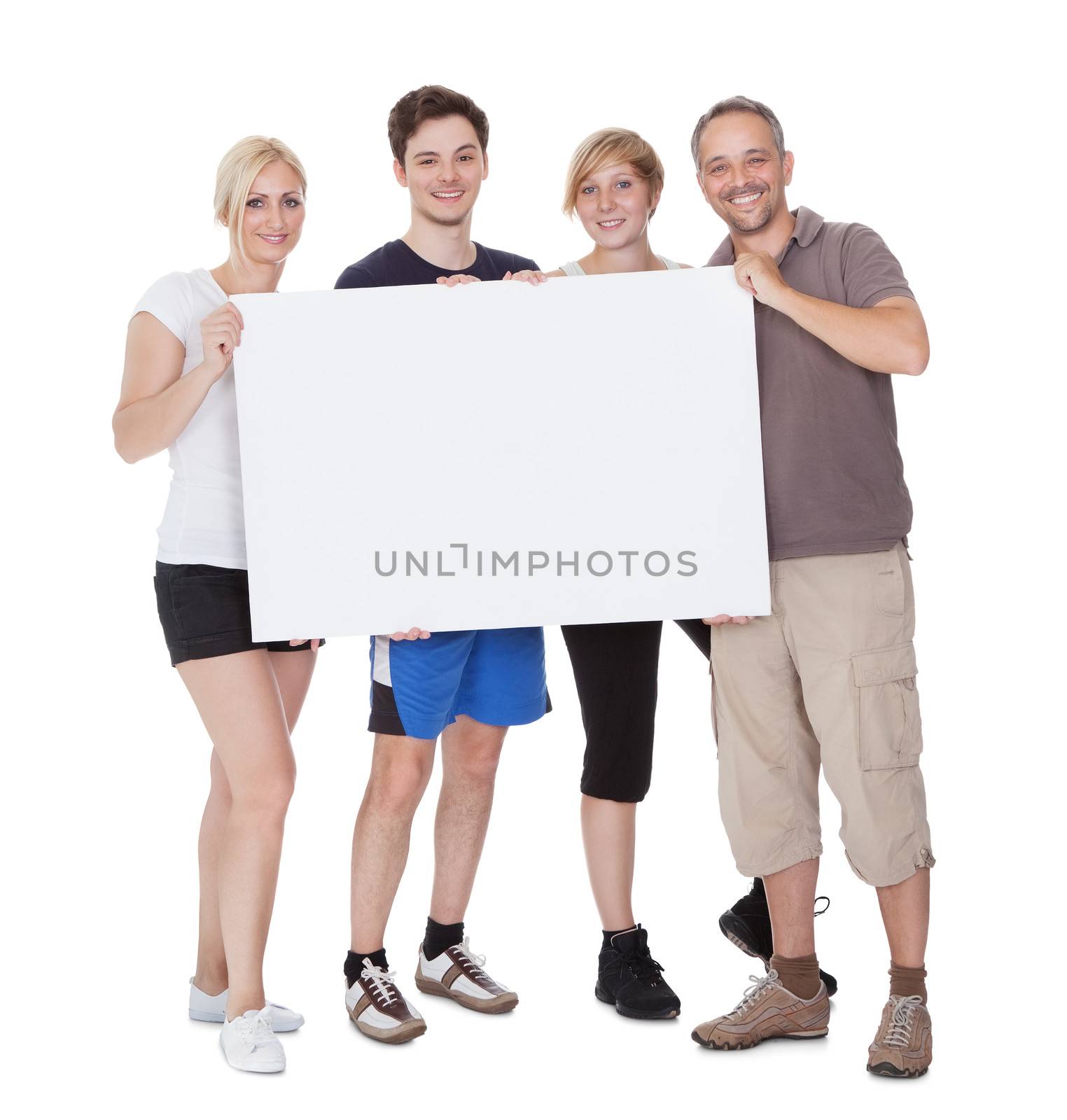 Happy family holding blank placard by AndreyPopov