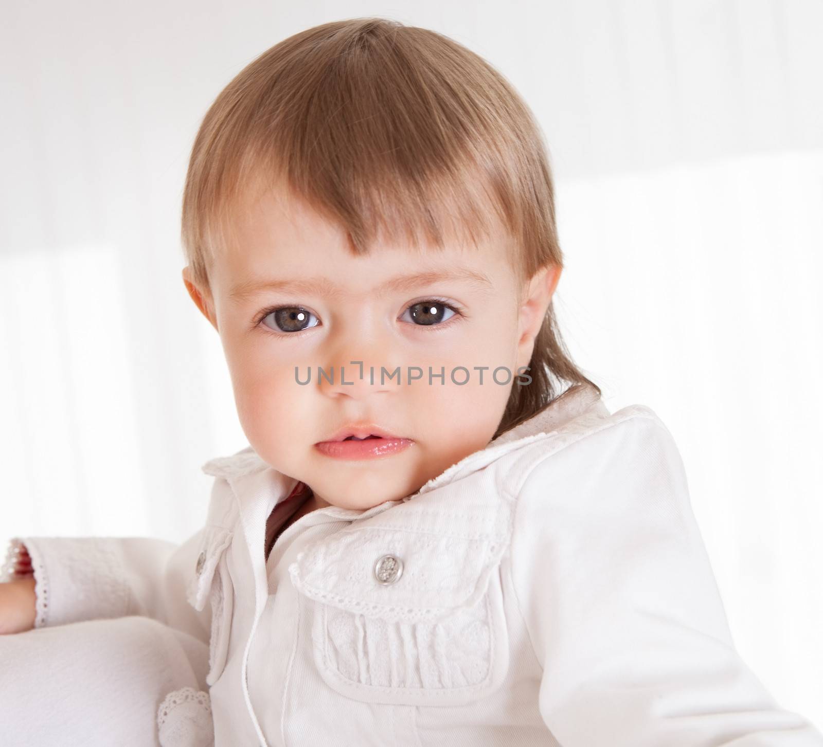 Portrait of a cute innocent young baby smiling and looking with love