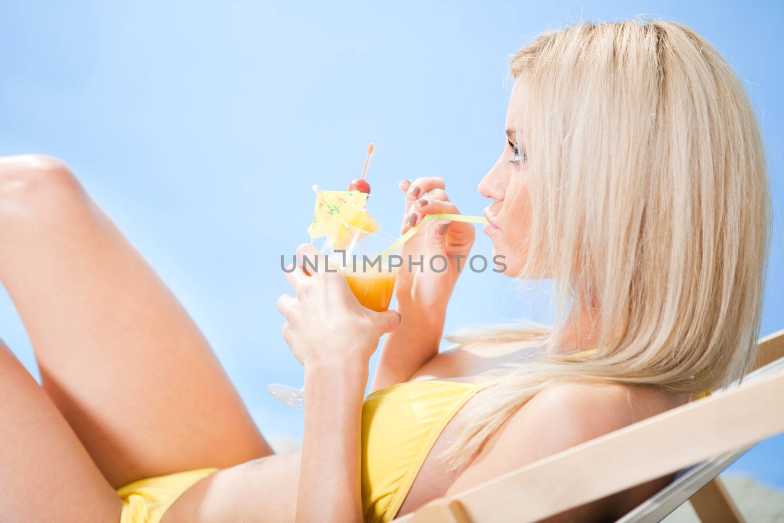 Beautiful young woman in bikini  drinking cocktail by AndreyPopov