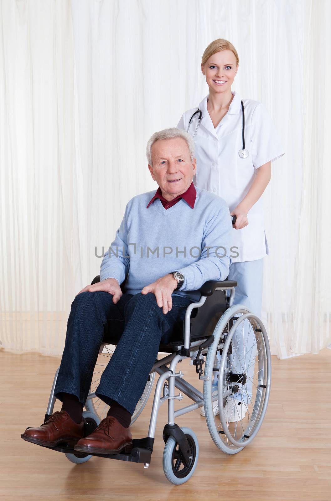 Caring Doctor Helping Handicapped Senior Patient Indoors