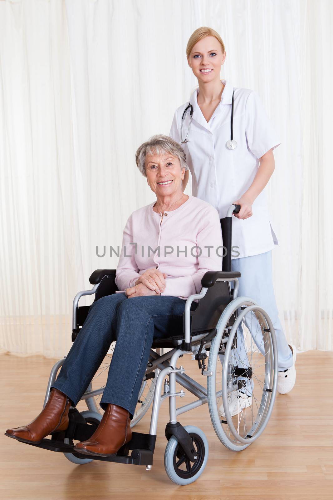 Caring Doctor Helping Handicapped Senior Patient Indoors