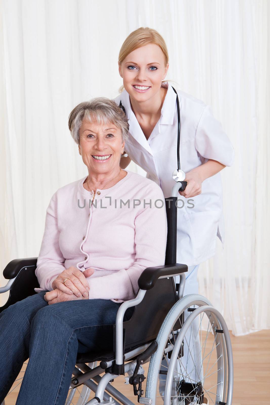 Caring Doctor Helping Handicapped Senior Patient Indoors