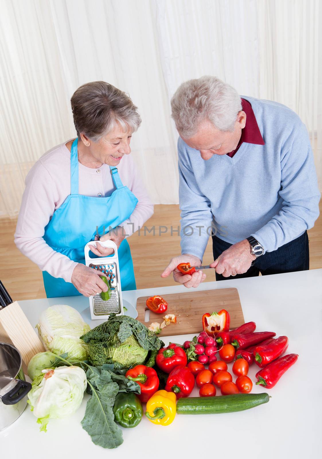 Senior Couple Cutting Vegetables by AndreyPopov