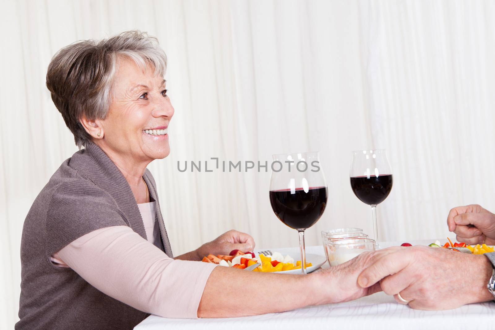 Portrait Of Senior Couple With Wine Glasses Sitting At A Restaurant