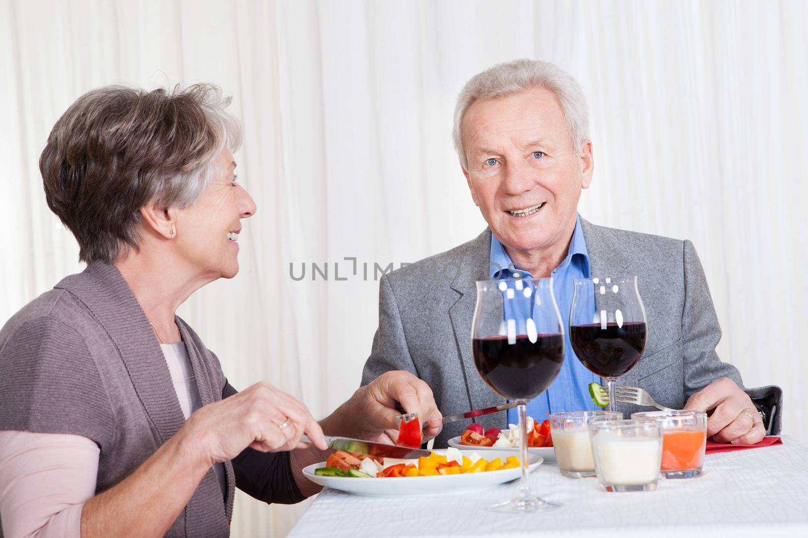 Portrait Of Senior Couple With Wine Glasses Sitting At A Restaurant