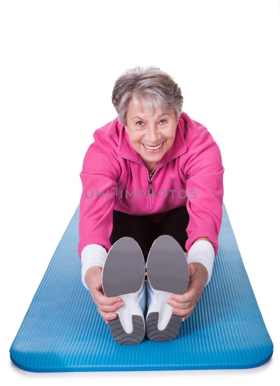 Happy Senior Woman Stretching Her Legs On White Background