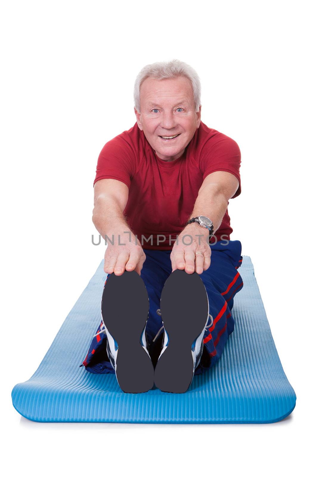 Happy Senior Man Stretching His Legs On White Background