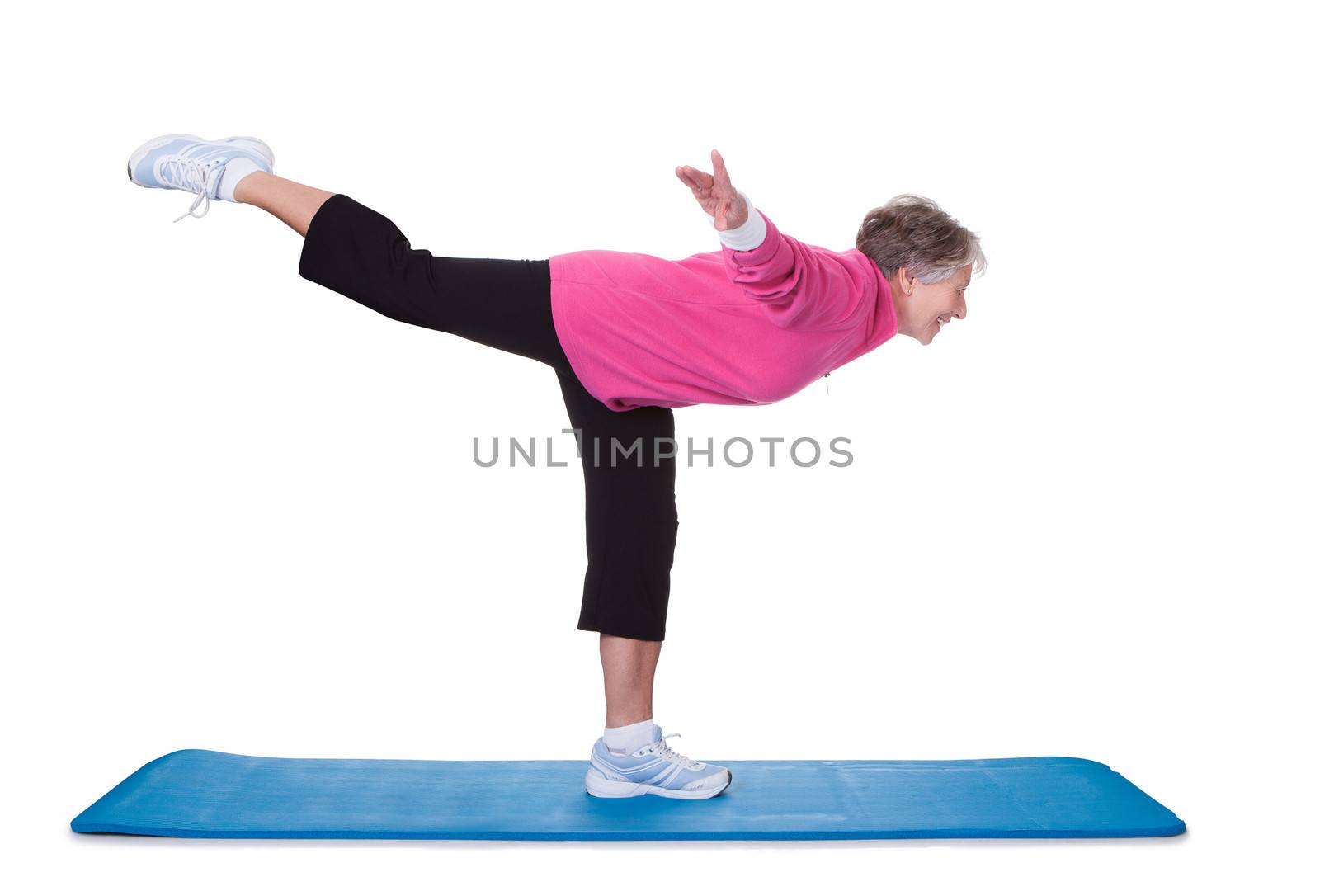 Senior Woman Standing On One Leg And Exercising Over White Background