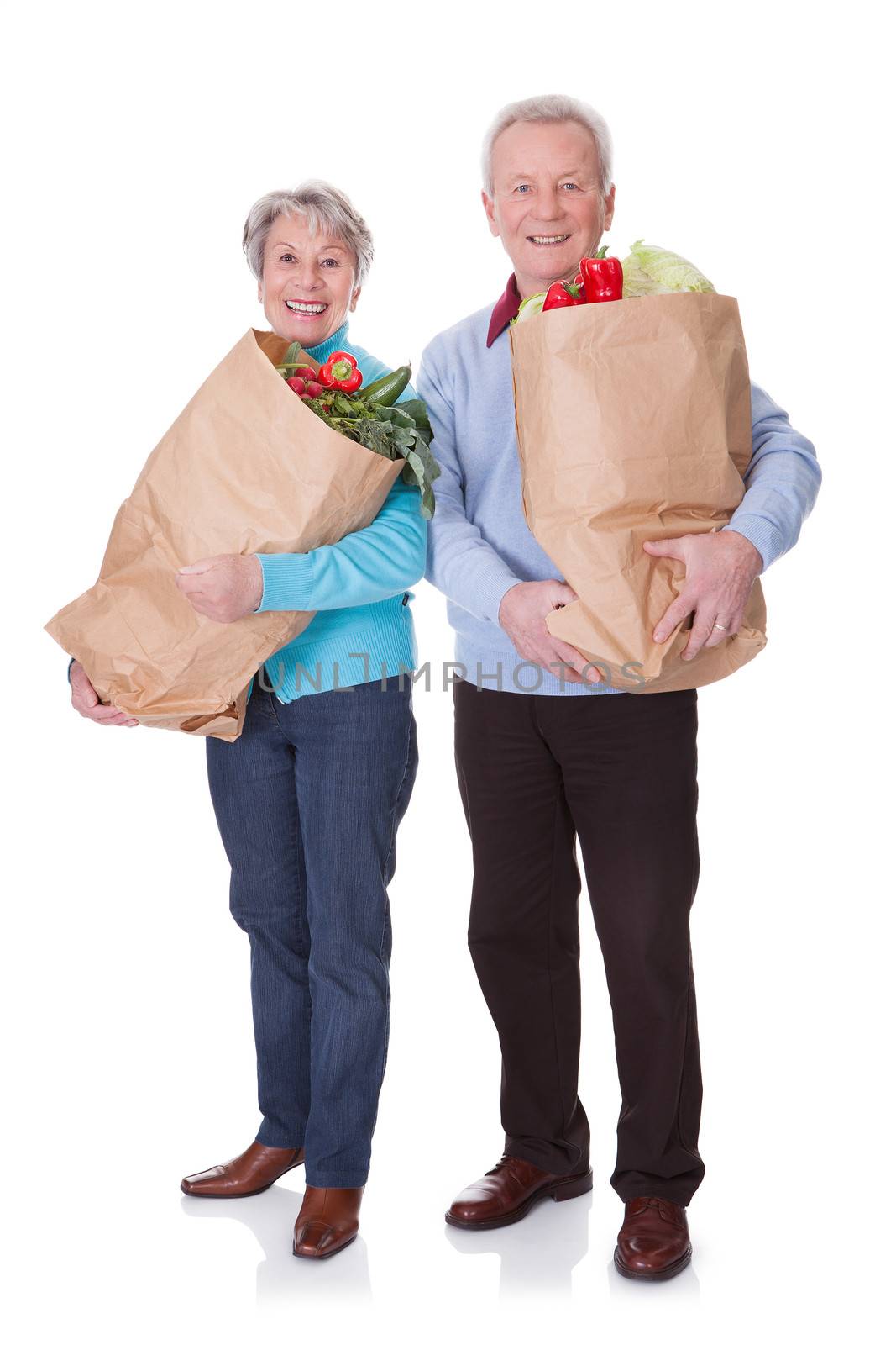 Portrait Of Happy Senior Couple Shopping Fresh Vegetables