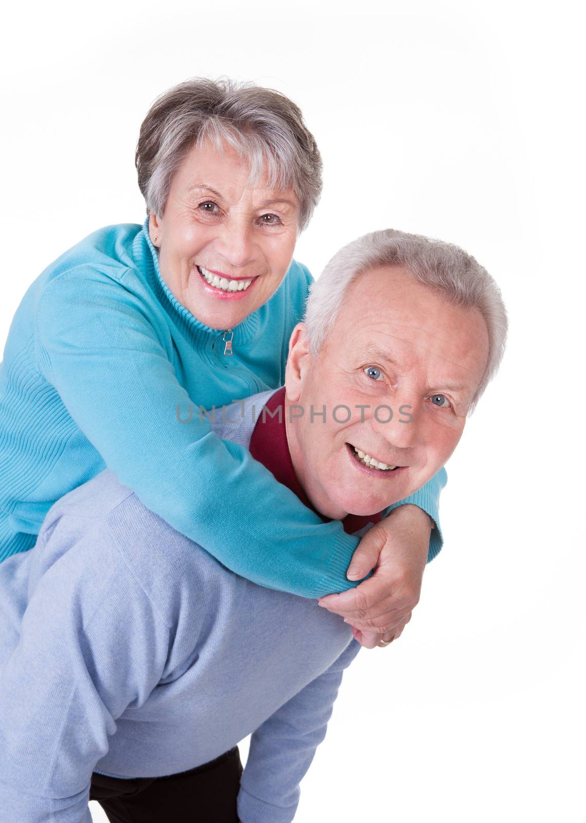 Portrait Of Senior Couple Enjoying Piggyback Isolated On White Background