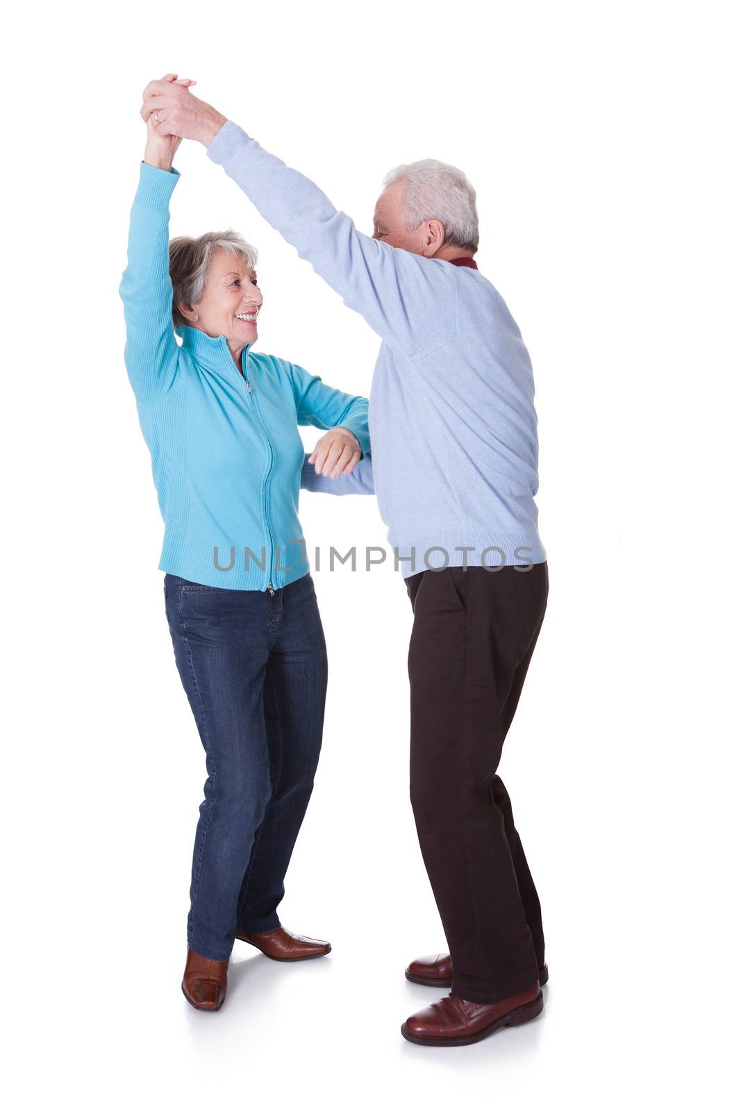 Portrait Of Senior Couple Dancing On White Background