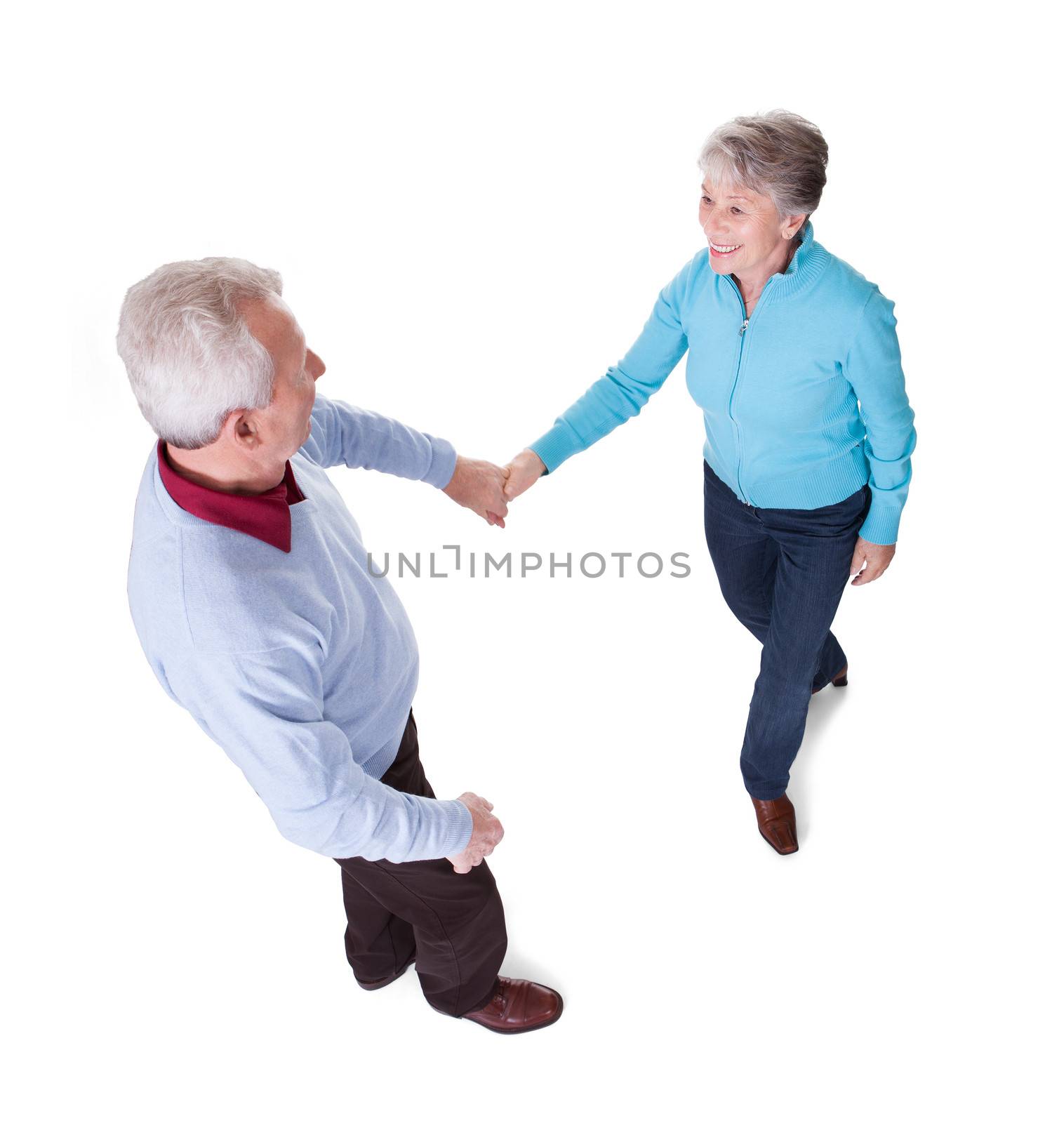 Portrait Of Senior Couple Dancing On White Background